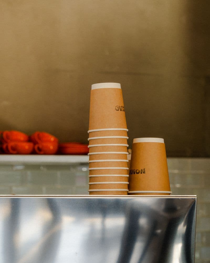 Stack of brown paper cups in cafรฉ